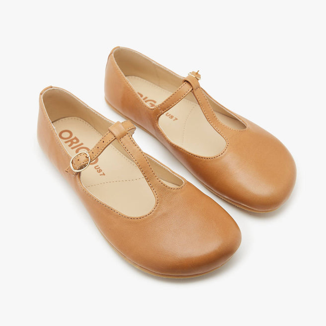 The Women's T Strap Color barefoot flat Honey in a white background 2