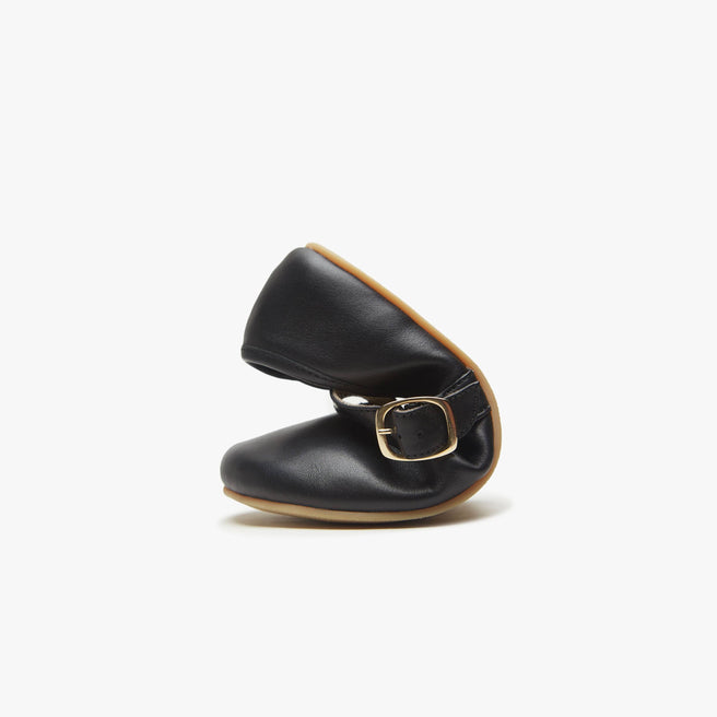 Black leather Women's Classic Mary Jane bent in half to show the flexible barefoot sole.