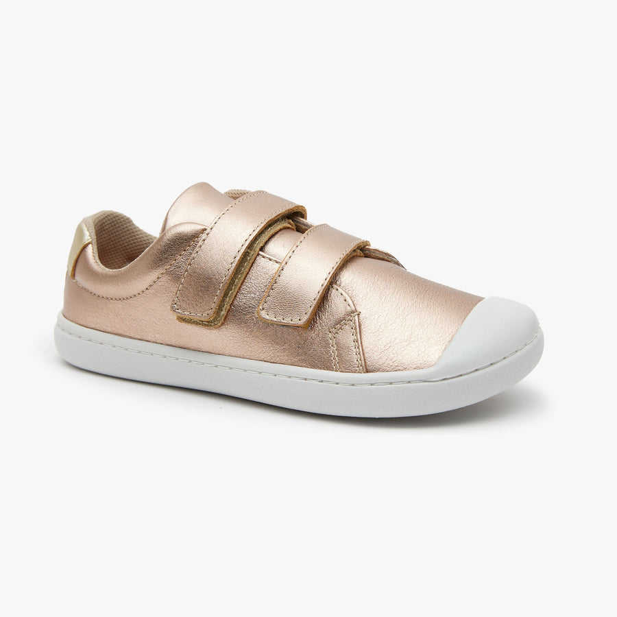Rose gold metallic leather Kid's Hook & Loop sneaker by Origo with two straps and white sole, angled side view.