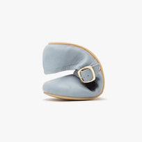 Light blue flat barefoot shoe with a gold buckle on a white background