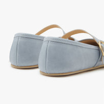 Pair of light blue mary janes flats with tan soles on a white background